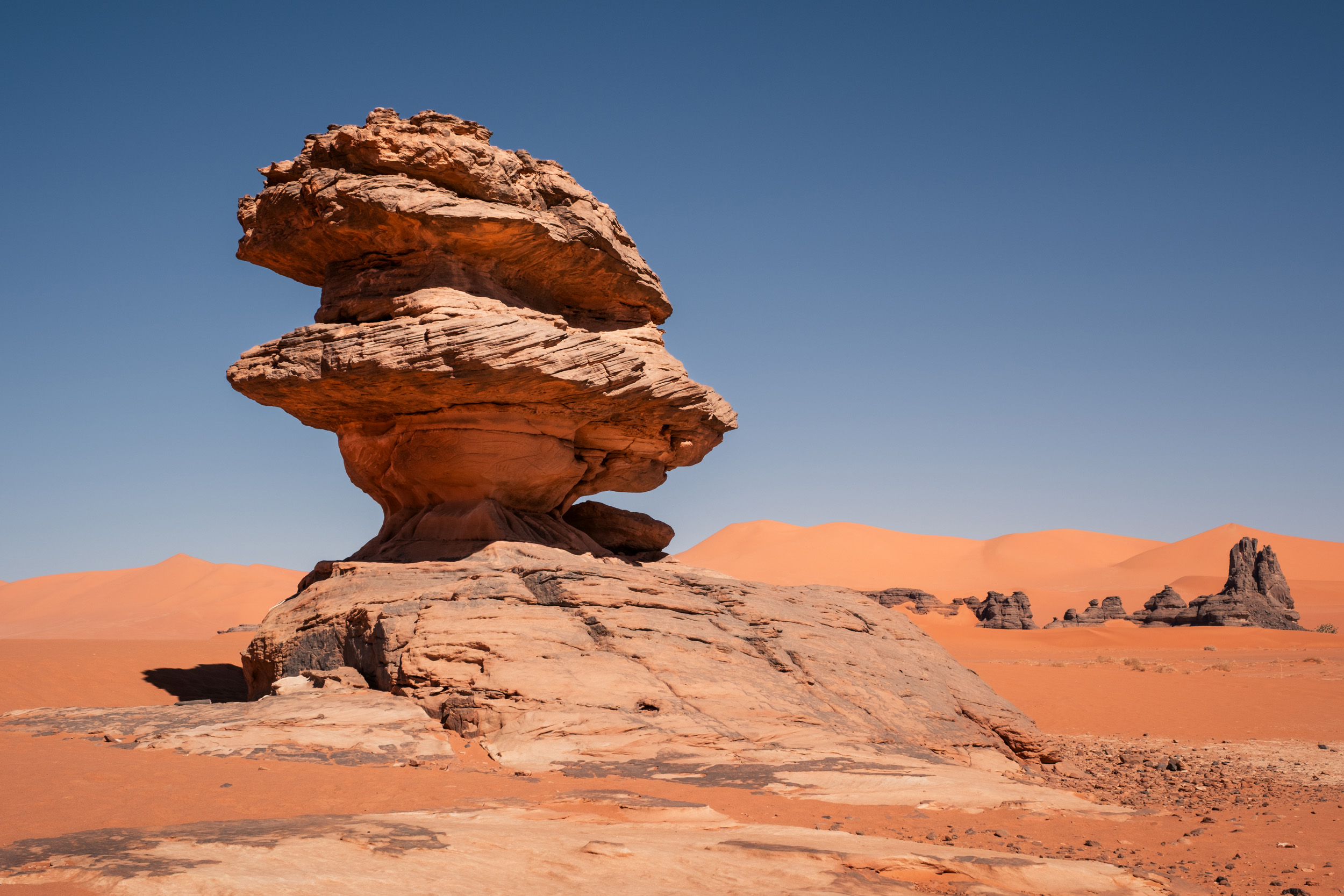 Red sand dunes in Tadrart Sahara, Algeria with dramatic formations