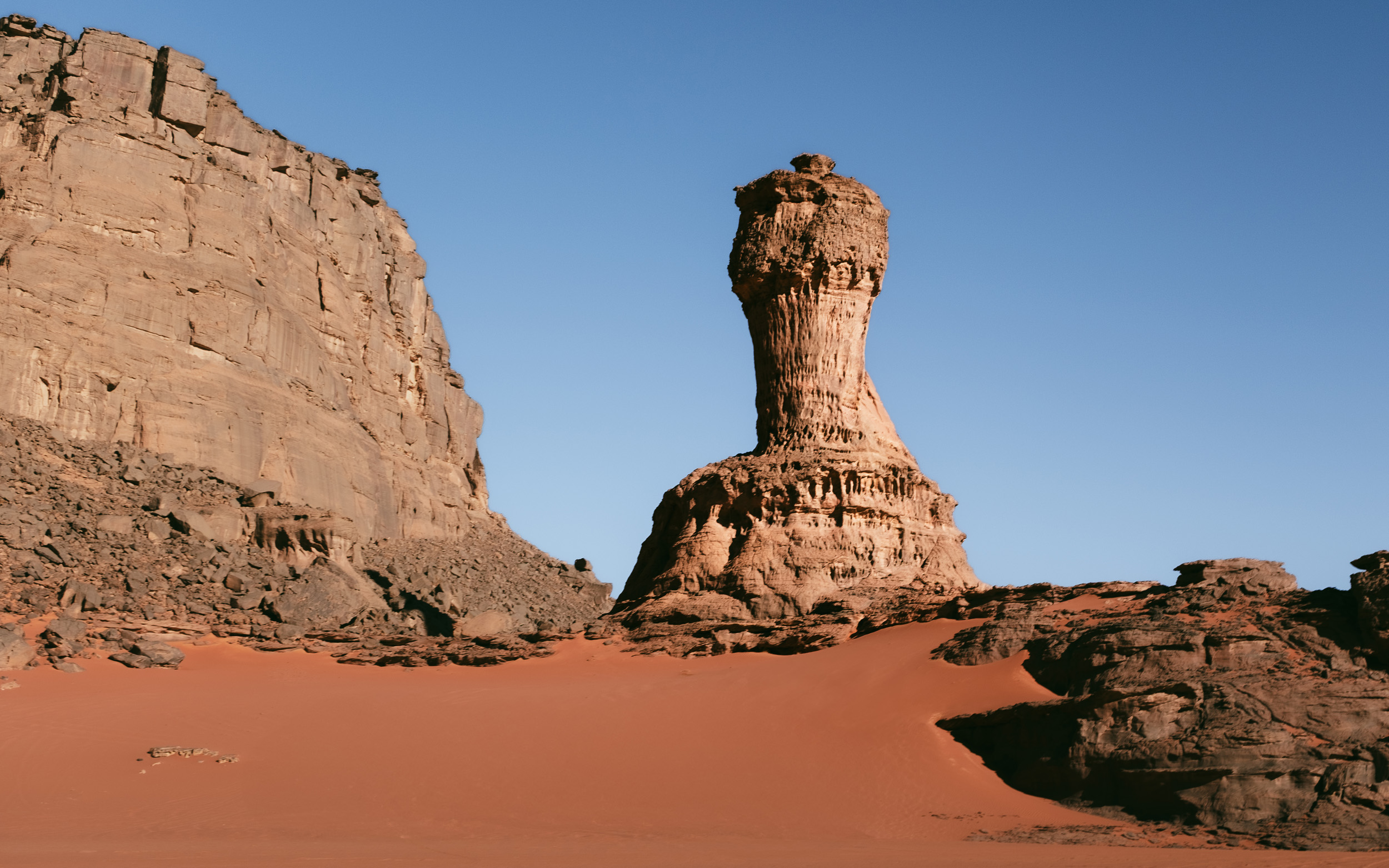 Red sand dunes in Tadrart Sahara, Algeria with dramatic formations
